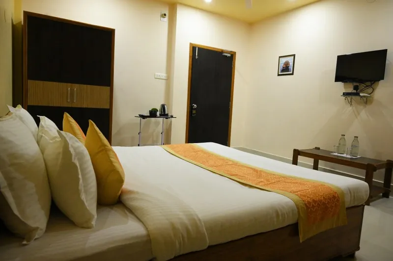 A double room with a wardrobe, cushions and a side table — Shree Chaitanya Gaudiya Math, Puri
