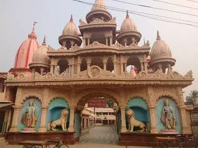 The carved sandstone gateway of the Math, with lions and standing figures — Shree Chaitanya Gaudiya Math, Puri