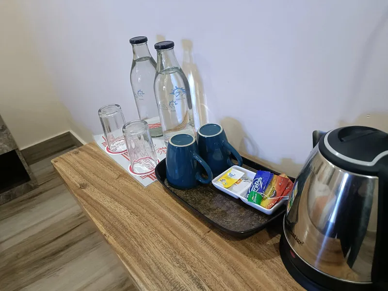 A kettle, cups and sealed drinking water on the room desk — Shree Chaitanya Gaudiya Math, Puri