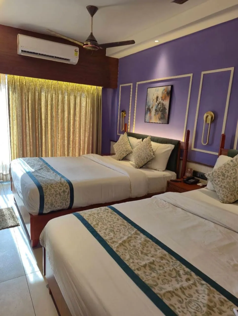 A family suite with two double beds made up in white, an air conditioner and framed pictures — Shree Chaitanya Gaudiya Math, Puri